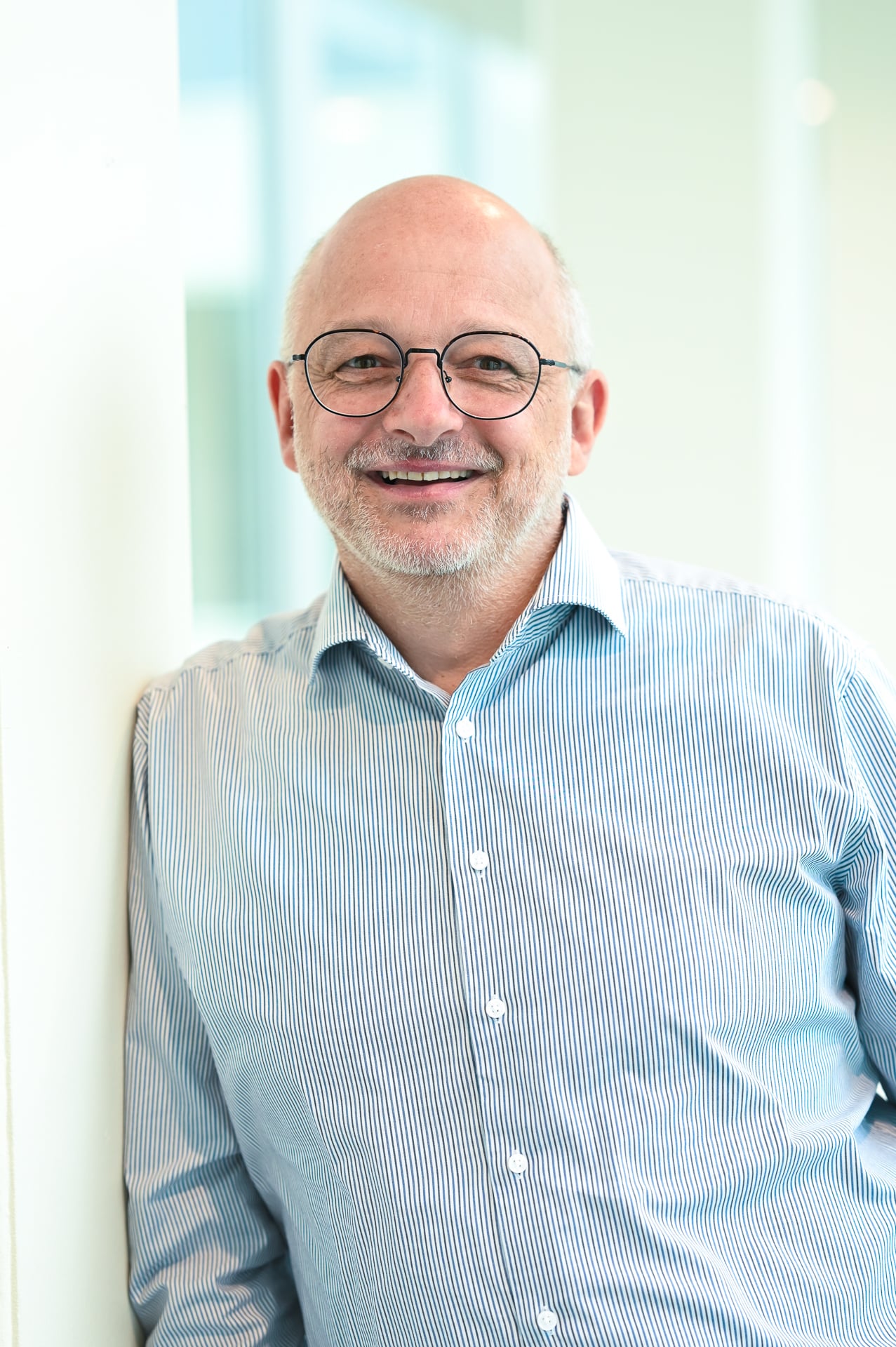 Mann mit Brille und Hemd lächelt