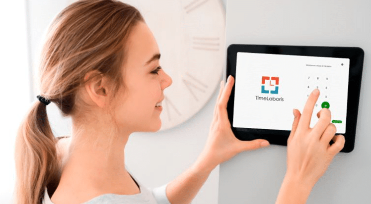 Frau benutzt Tablet an der Wand.