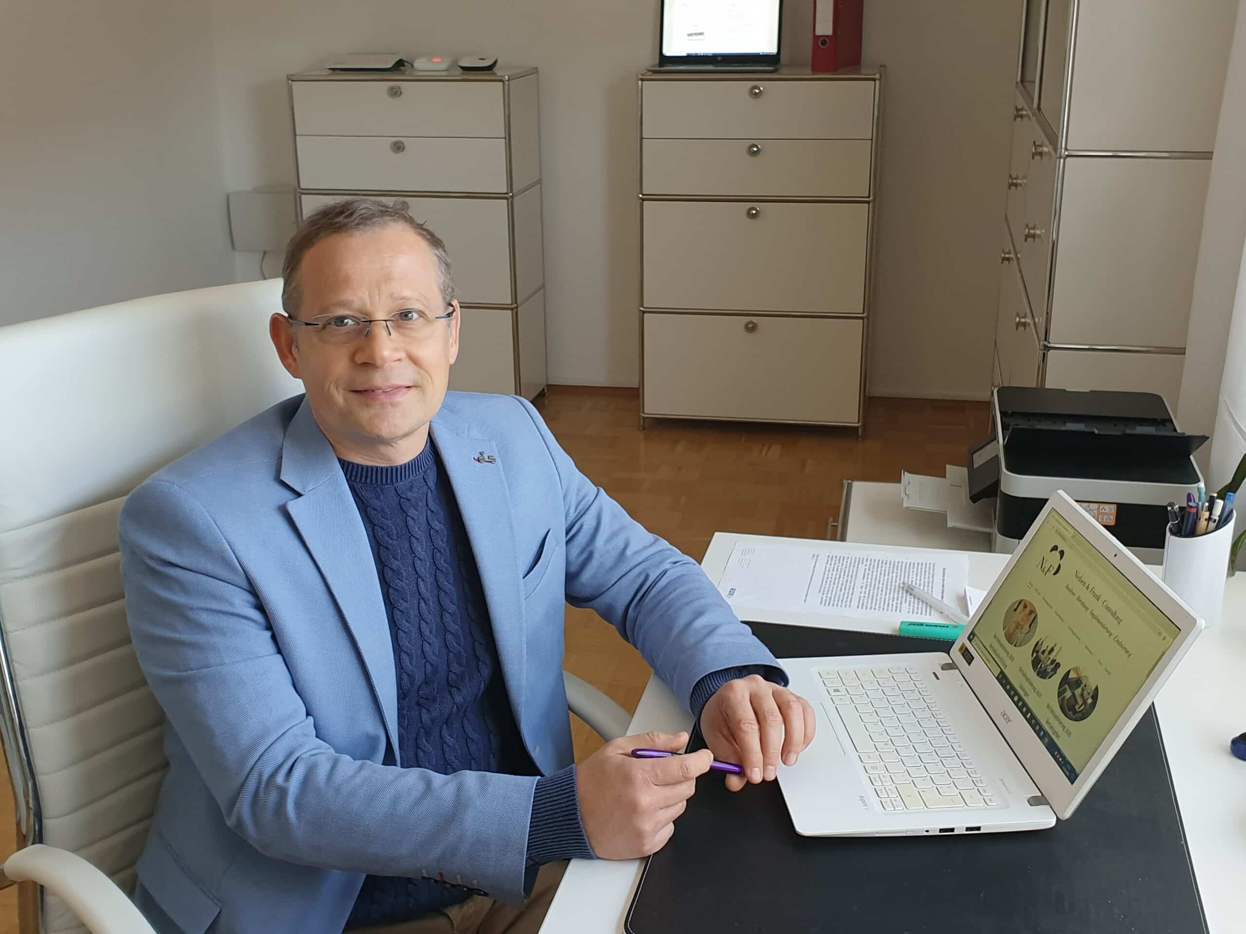 Mann im Büro an Laptop