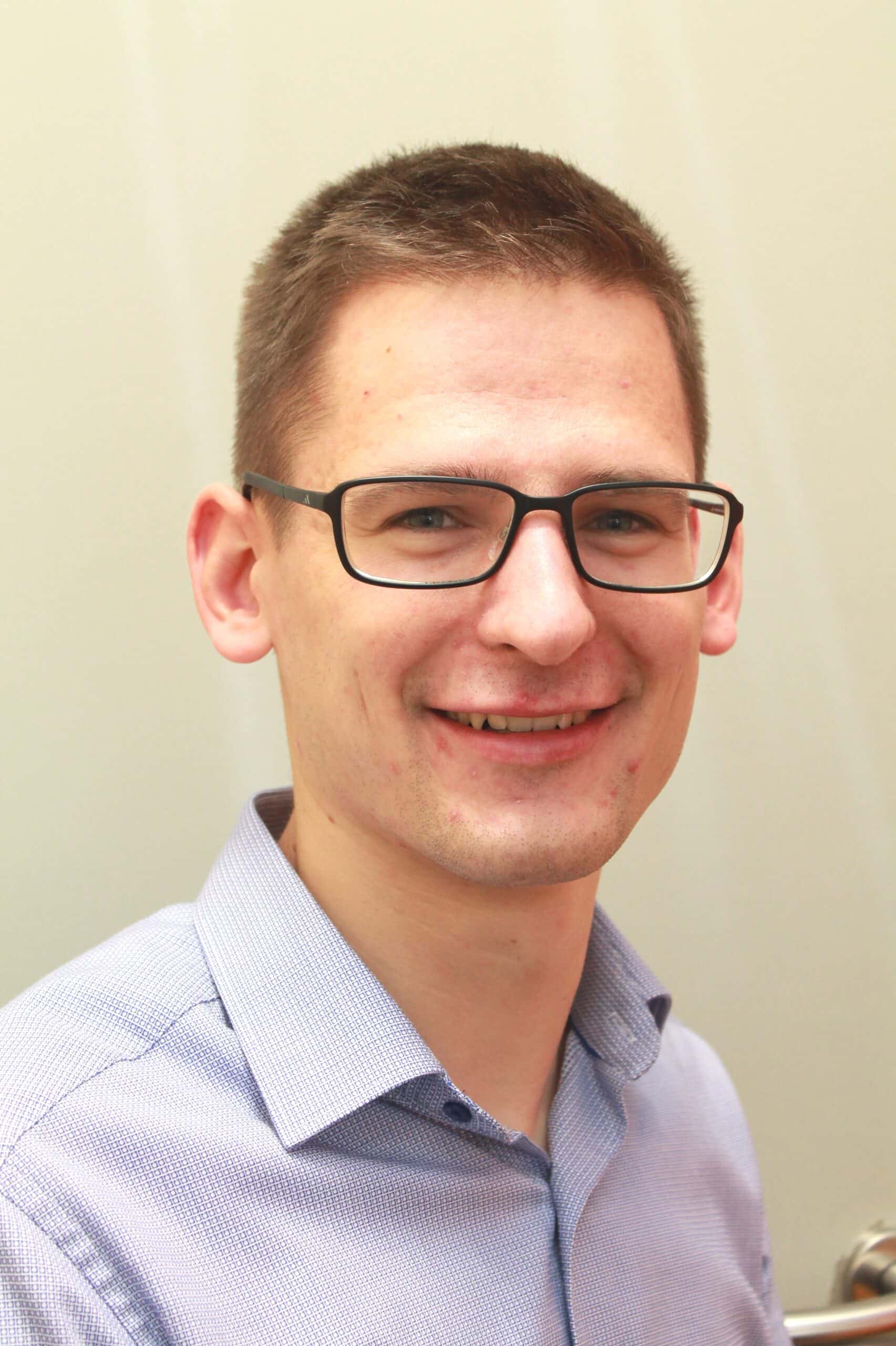 Mann mit Brille und Hemd lächelt freundlich